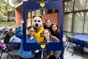 Four Postdocs posing in blue frame with Oski the UC Berkeley mascot