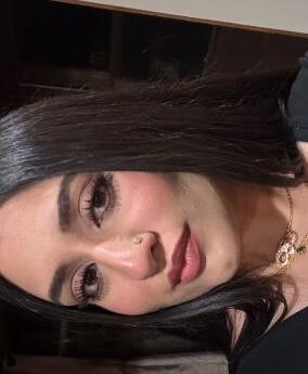 Headshot of Prishaa Vala in a black top wearing gold chains.
