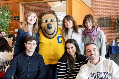 Scholars posing with Oski the bear