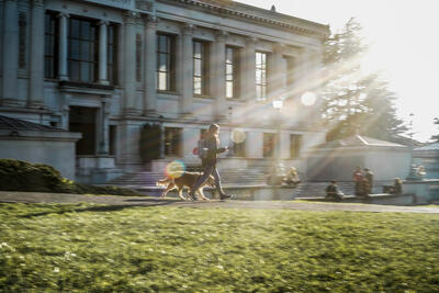 UC Berkeley Library with person walking dog in sunlight rays