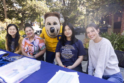 Visiting Scholar and Postdoc Affairs Student Team and Oski Bear at registration table