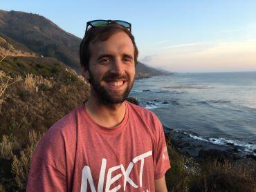 Mark Plitt standing with shoreline in background.