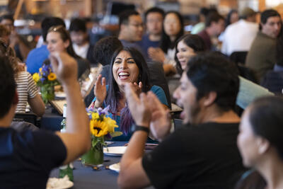 Postdoc smiling and chatting with other postdocs at Postdocfest event.